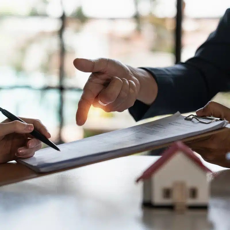 mans hand pointing to papers on clipboard
